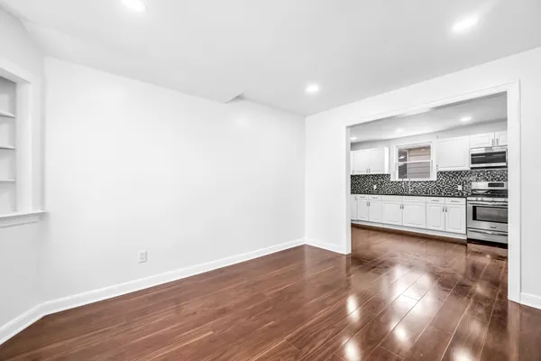 a view of a kitchen with wooden floor and windows