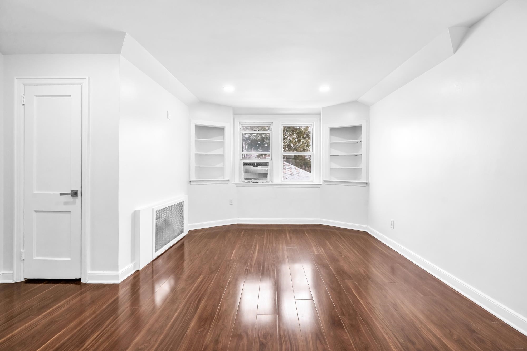 284 MacArthur Avenue, Unit 2 Garfield, NJ 07026 - Photo 7 of 19 an empty room with wooden floor and windows