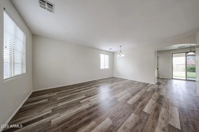 a kitchen with granite countertop white cabinets appliances a sink and a window