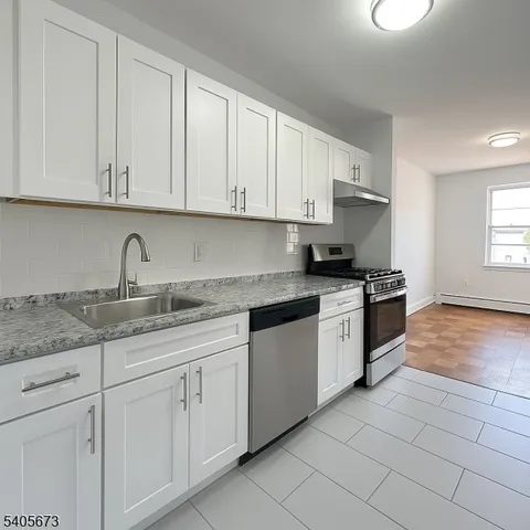 a kitchen with granite countertop white cabinets and white appliances