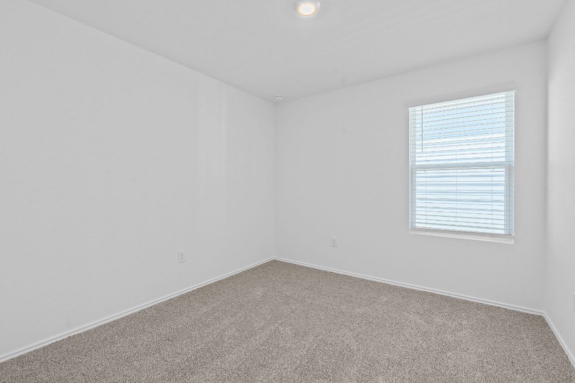 13309 Mancos Shale Road Mustang Ridge, TX 78610 - Photo 13 of 19 Spare room with carpet flooring and recessed lighting