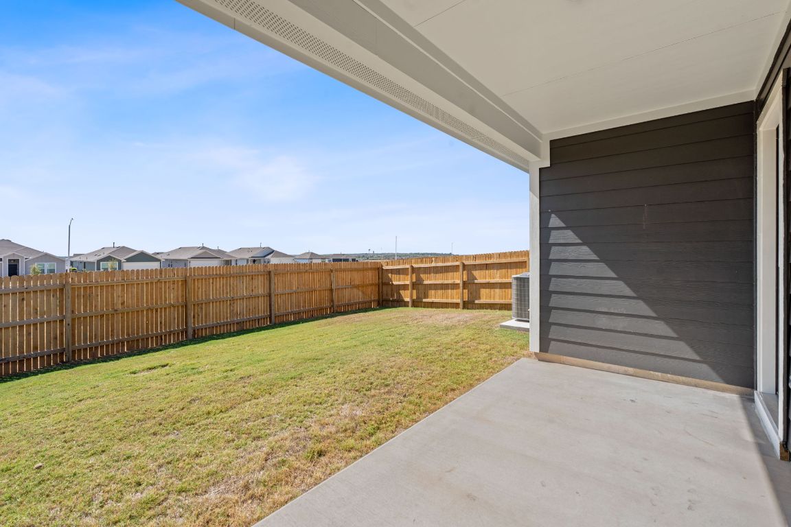 13309 Mancos Shale Road Mustang Ridge, TX 78610 - Photo 17 of 19 Fenced backyard featuring a patio and a residential view