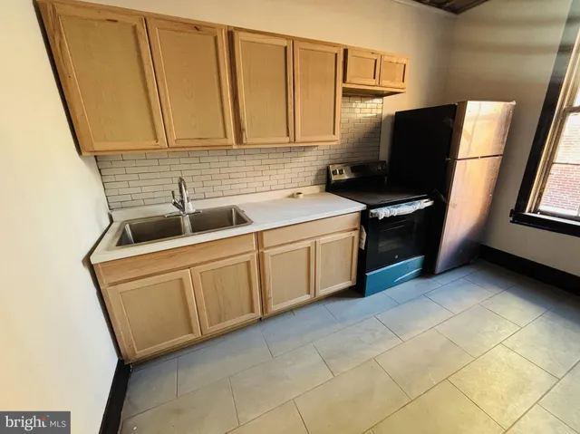 a kitchen with a refrigerator sink and cabinets
