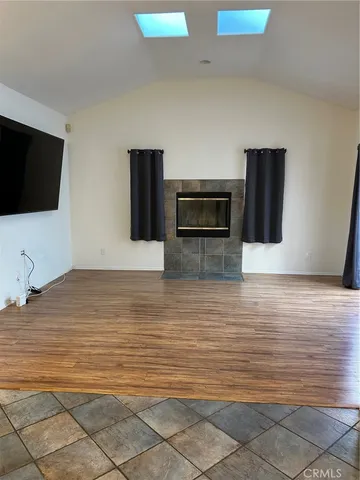 a view of a livingroom with an empty space & wooden floor