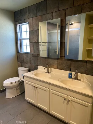 a bathroom with a sink a toilet and mirror