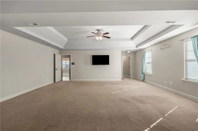 an empty room with windows and a ceiling fan