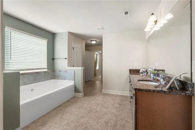 a bathroom with a tub sink and mirror