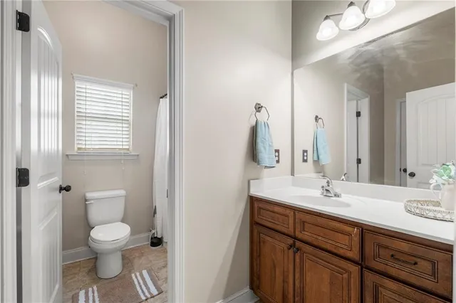 a bathroom with a toilet sink and mirror