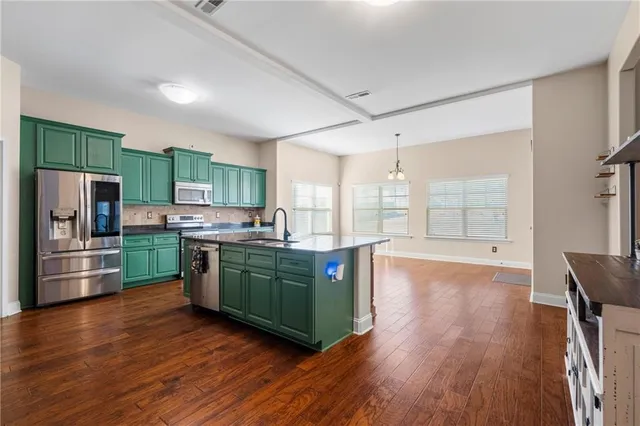 a kitchen with stainless steel appliances wooden floors and refrigerator