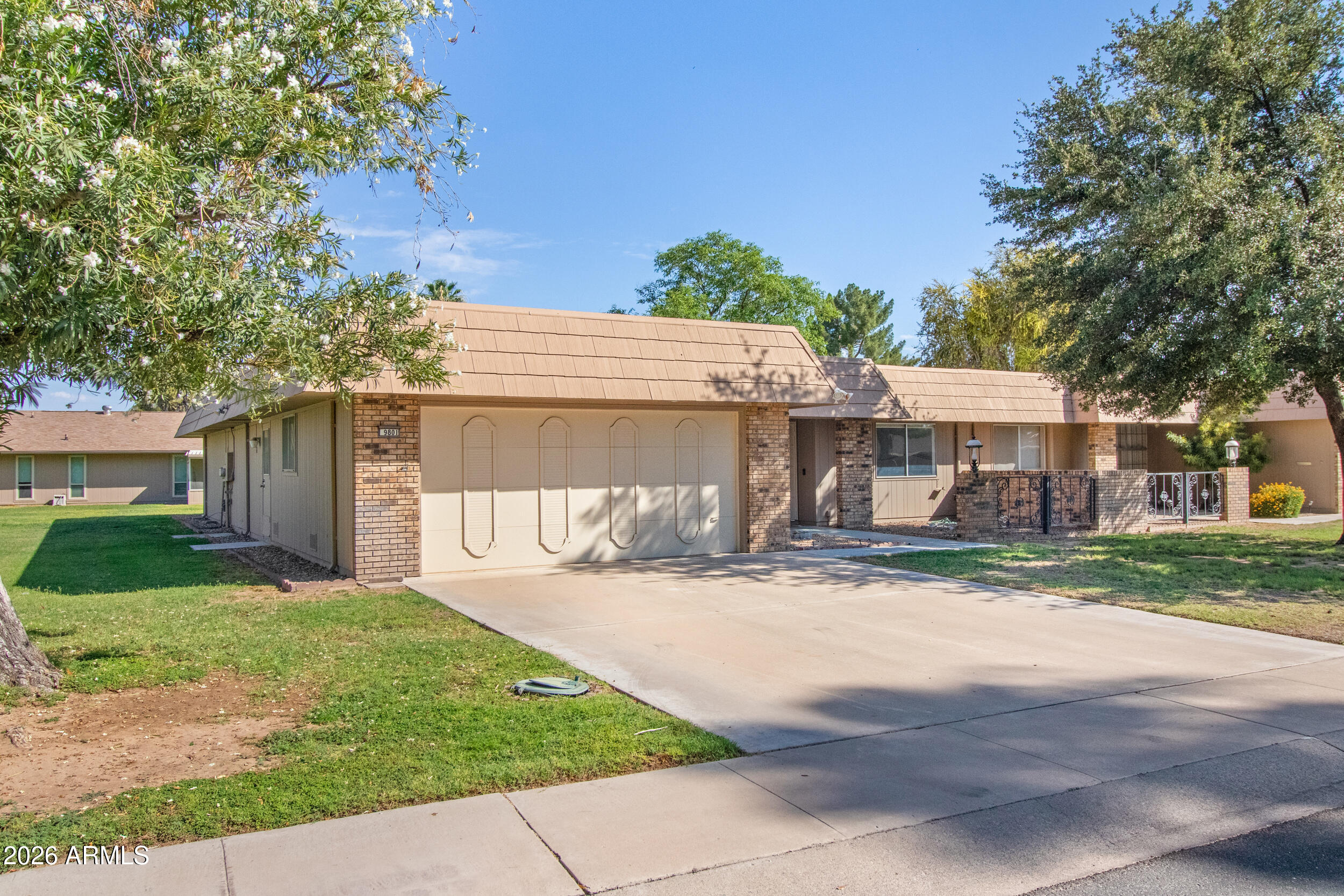 9801 West Pleasant Valley Road Sun City, AZ 85351 - Photo 2 of 26 a front view of a house with a yard and garage
