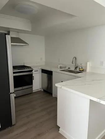 a kitchen with stainless steel appliances a stove a refrigerator and a sink