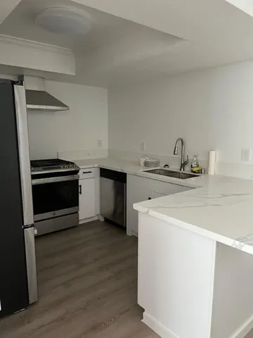a kitchen with stainless steel appliances a stove a refrigerator and a sink