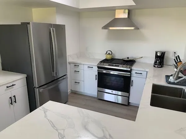a kitchen with a stove and a wooden floor