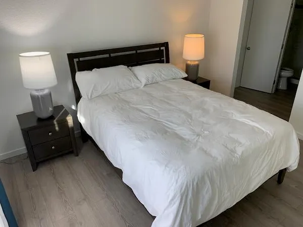 a large bed sitting in a bedroom next to a lamp