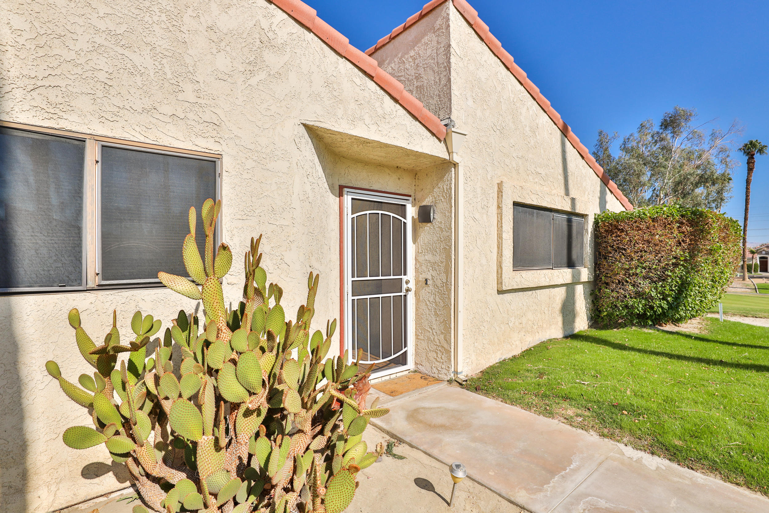 49058 Wayne Street Indio, CA 92201 - Photo 4 of 26 a front view of a house with a garden