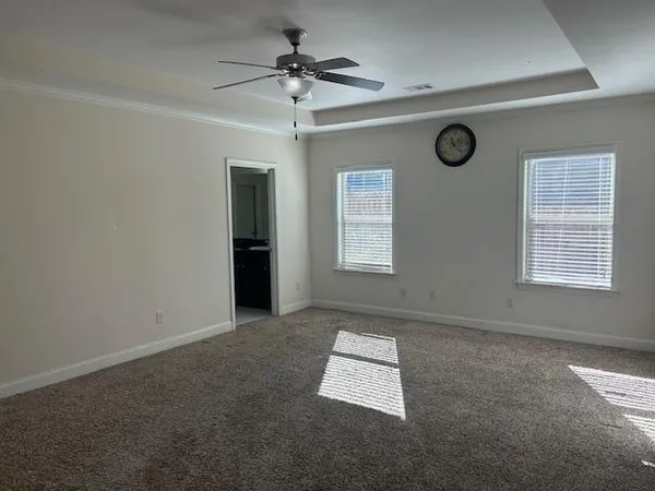 an empty room with windows and fan