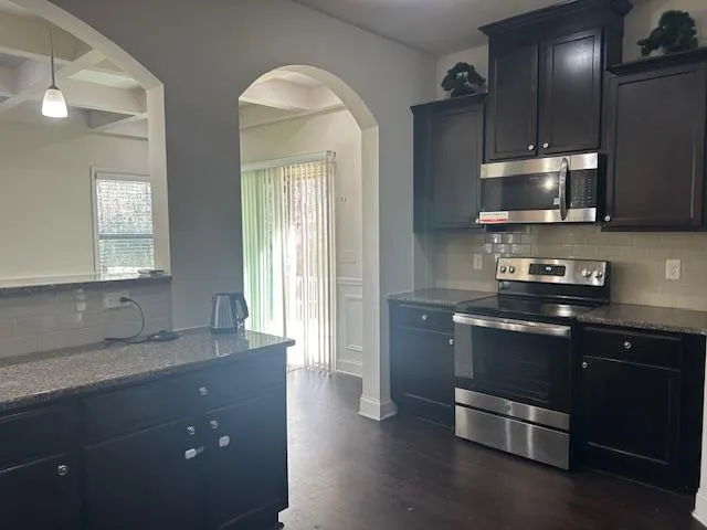 a kitchen with stainless steel appliances granite countertop a sink and a stove