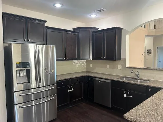 a kitchen with stainless steel appliances granite countertop a refrigerator and a sink