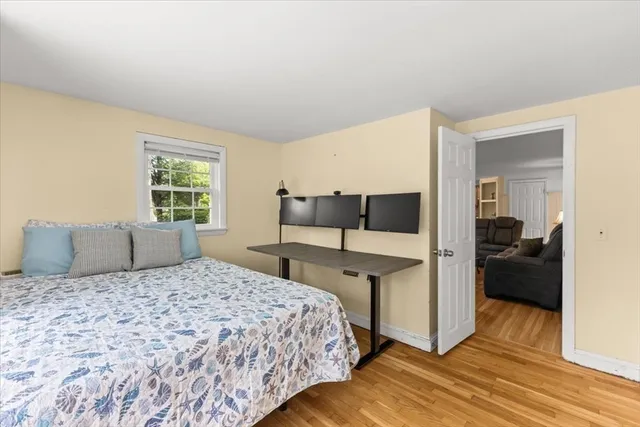 a bedroom with a bed and wooden floor