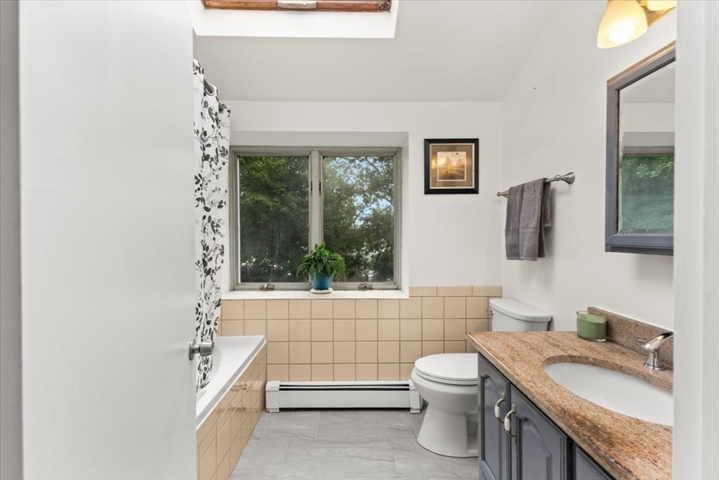 85 Maple Street Bourne, MA 02532 - Photo 19 of 42 a bathroom with a granite countertop toilet a sink and a large mirror
