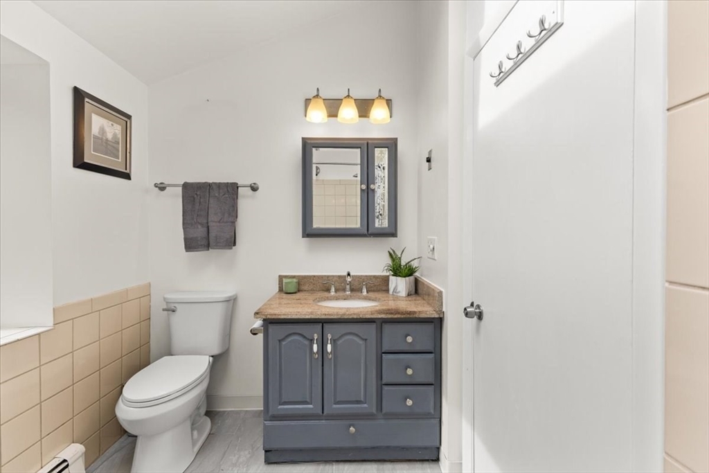 85 Maple Street Bourne, MA 02532 - Photo 20 of 42 a bathroom with a toilet sink vanity and mirror