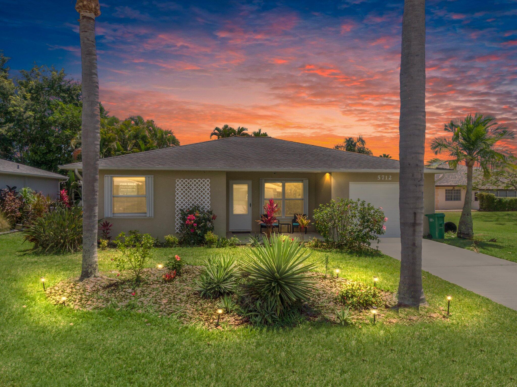 a view of a house with a big yard and potted plants