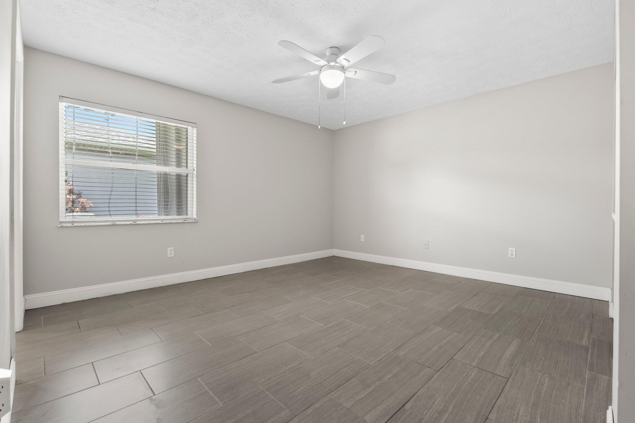 5712 Spindle Place Fort Pierce, FL 34982 - Photo 11 of 35 wooden floor in an empty room with a window