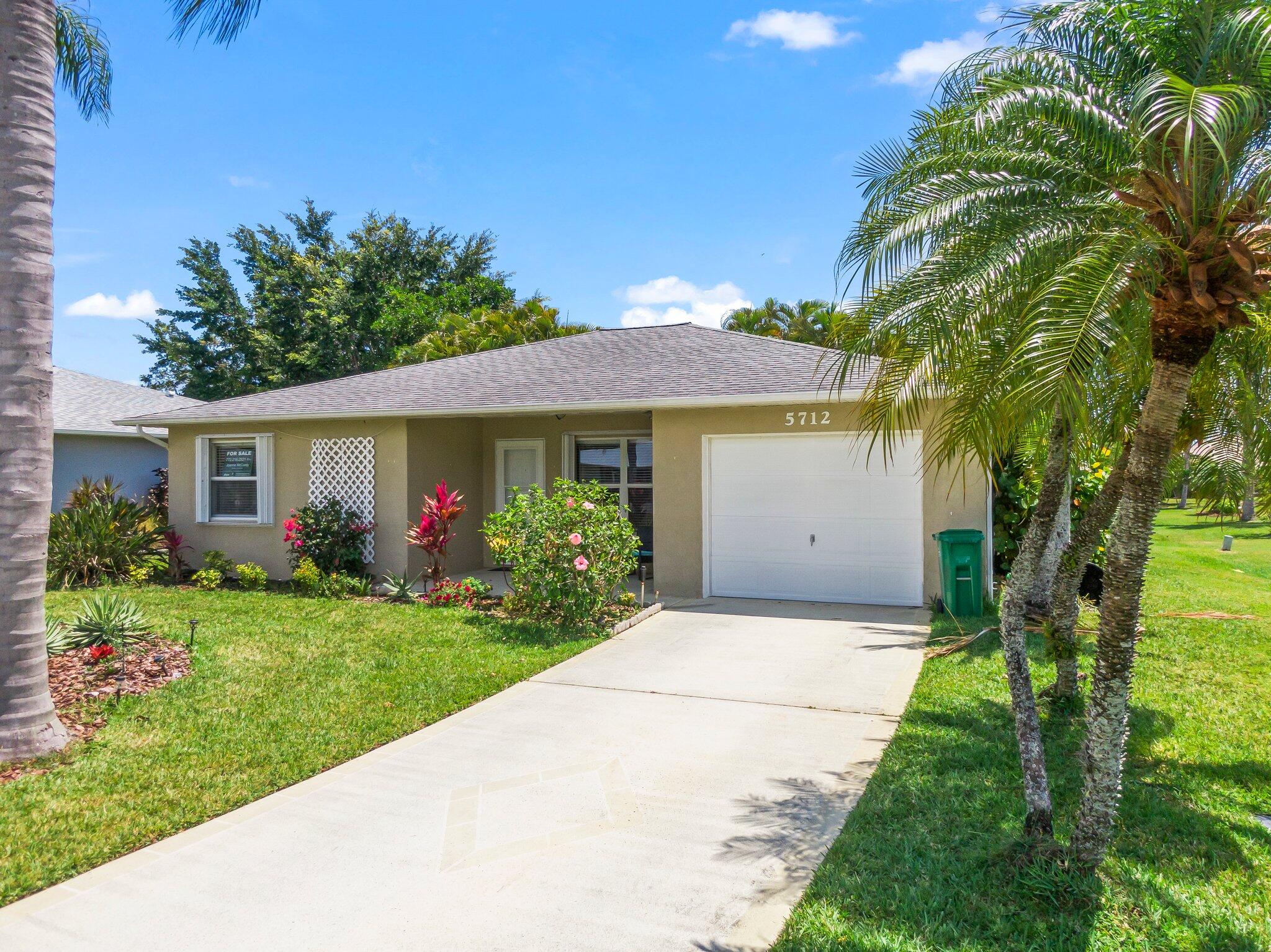 5712 Spindle Place Fort Pierce, FL 34982 - Photo 27 of 35 a front view of a house with a garden