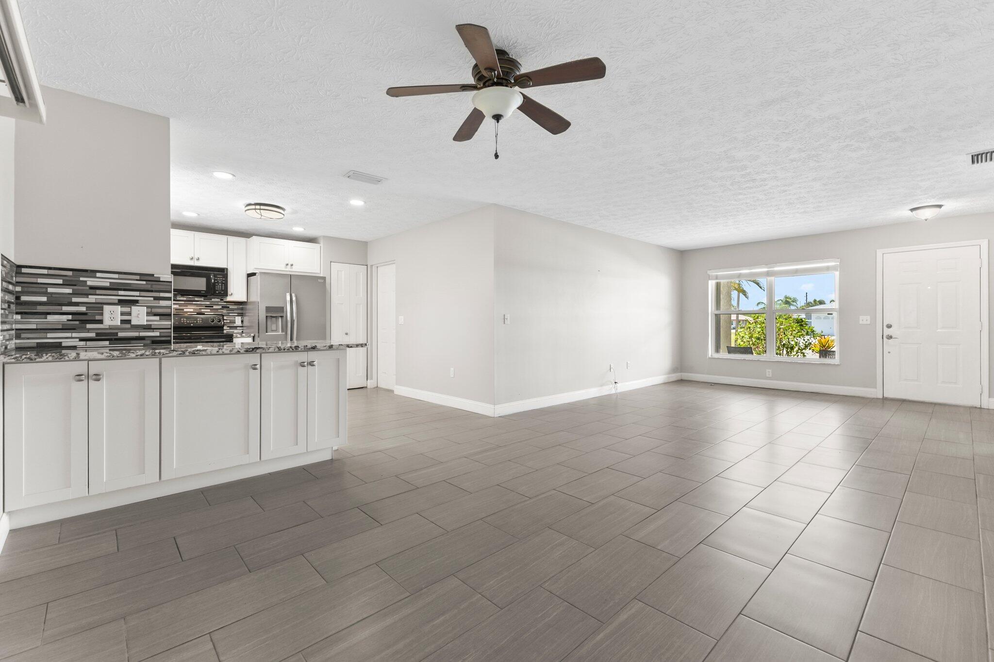 5712 Spindle Place Fort Pierce, FL 34982 - Photo 7 of 35 a view of kitchen with center island and stainless steel appliances