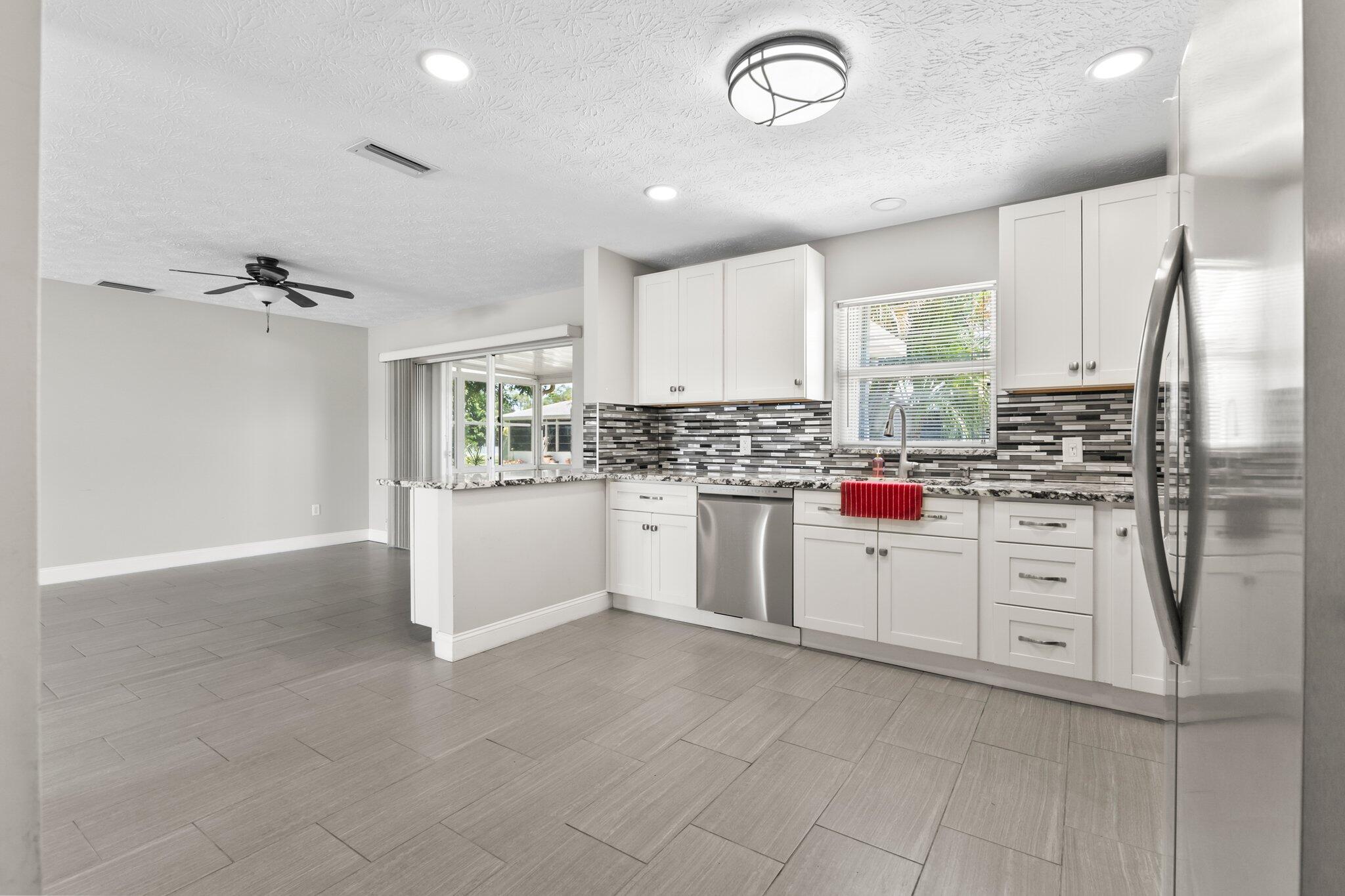5712 Spindle Place Fort Pierce, FL 34982 - Photo 8 of 35 a kitchen with white cabinets and white appliances