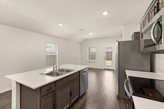 a kitchen with a sink cabinets and wooden floor