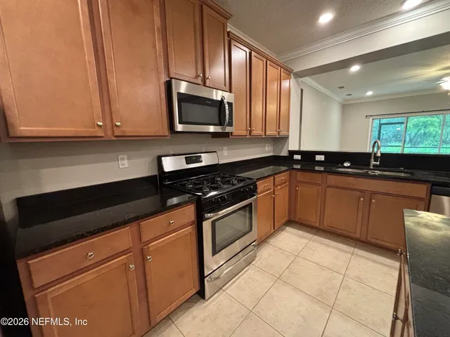 a view of an empty room with window and chandelier