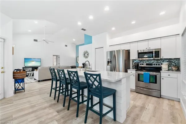 a kitchen with stainless steel appliances a stove a table and chairs refrigerator