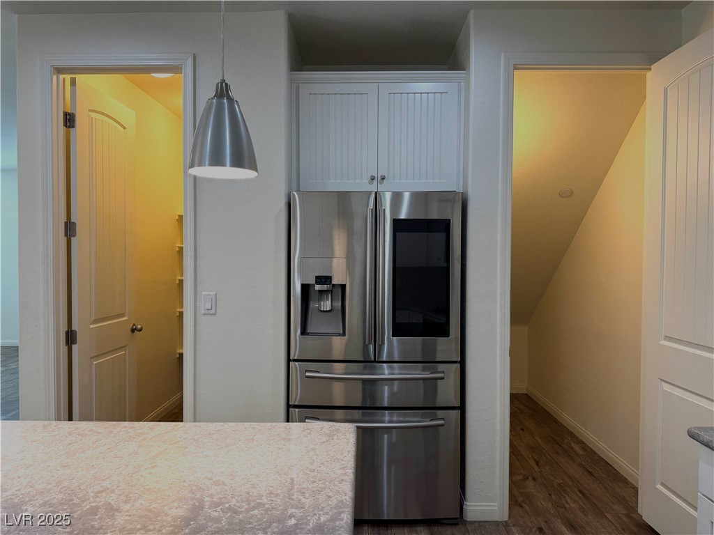 340 Mezzaforte Street Henderson, NV 89011 - Photo 9 of 39 Kitchen featuring stainless steel fridge, dark wood-type flooring, and white cabinetry