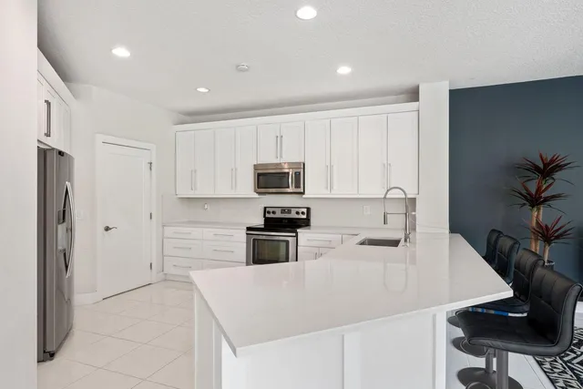 a kitchen with stainless steel appliances a stove refrigerator sink and cabinets