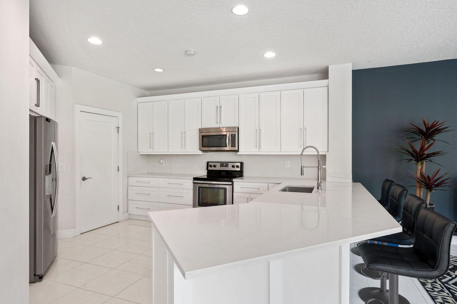 10982 Ravel Court Boca Raton, FL 33498 - Photo 14 of 44 a kitchen with stainless steel appliances a stove refrigerator sink and cabinets