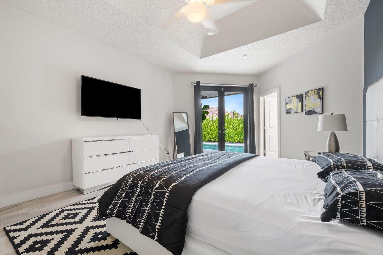 10982 Ravel Court Boca Raton, FL 33498 - Photo 19 of 44 a bedroom with a bed and a flat screen tv