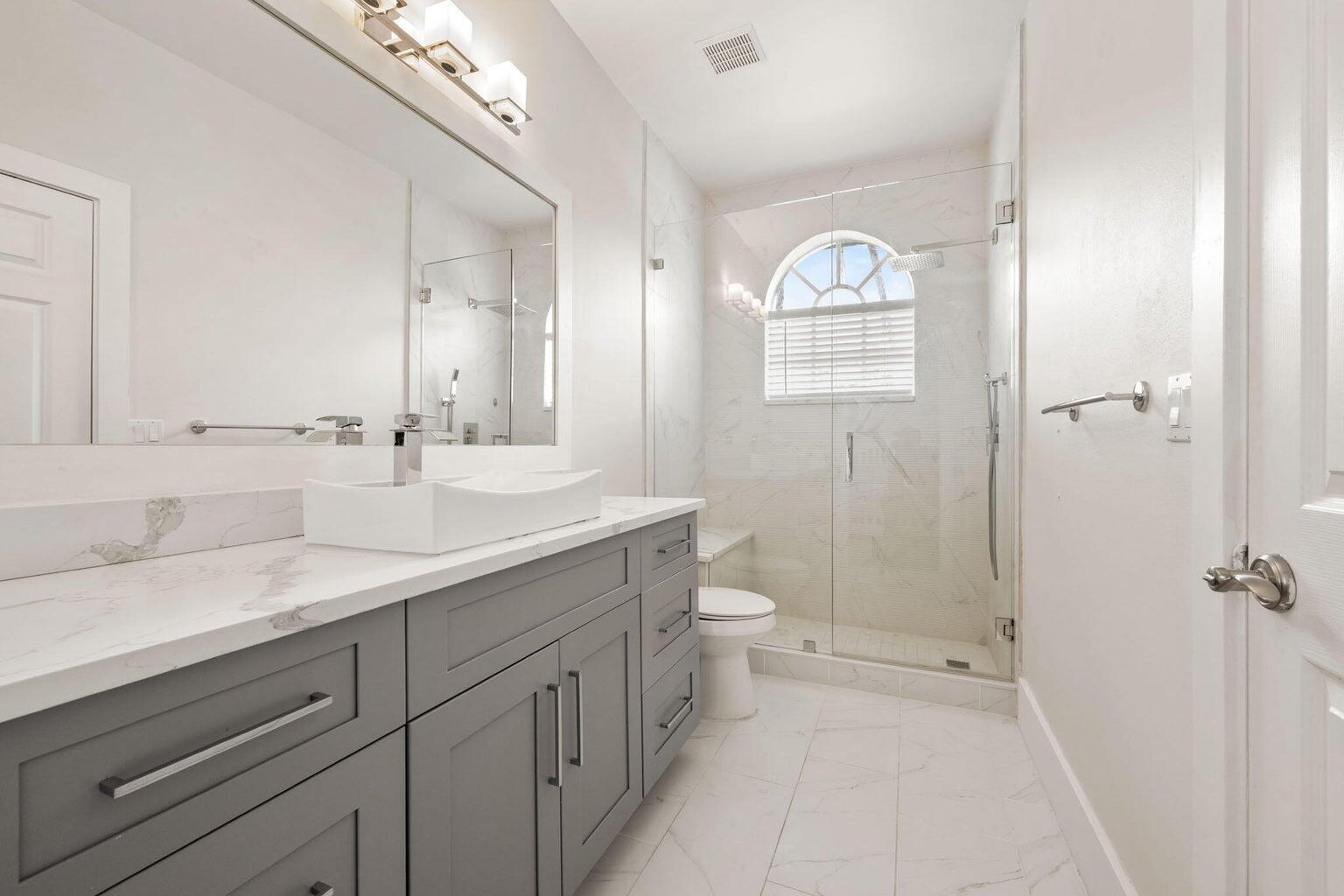 10982 Ravel Court Boca Raton, FL 33498 - Photo 24 of 44 a bathroom with a toilet a sink and mirror