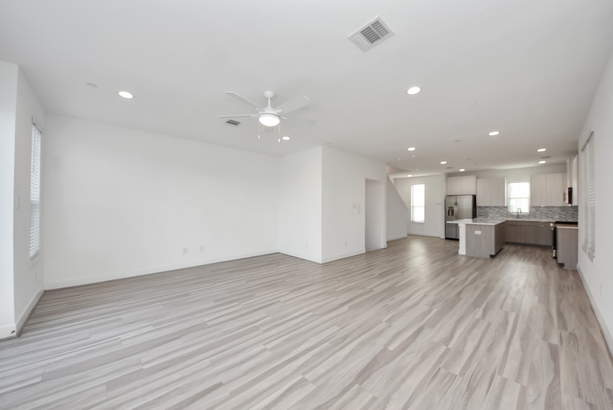 18716 Centro Main Street Conroe, TX 77385 - Photo 20 of 50 Open-concept living and dining area with recessed lighting, ceiling fan, and seamless connection to the kitchen.
