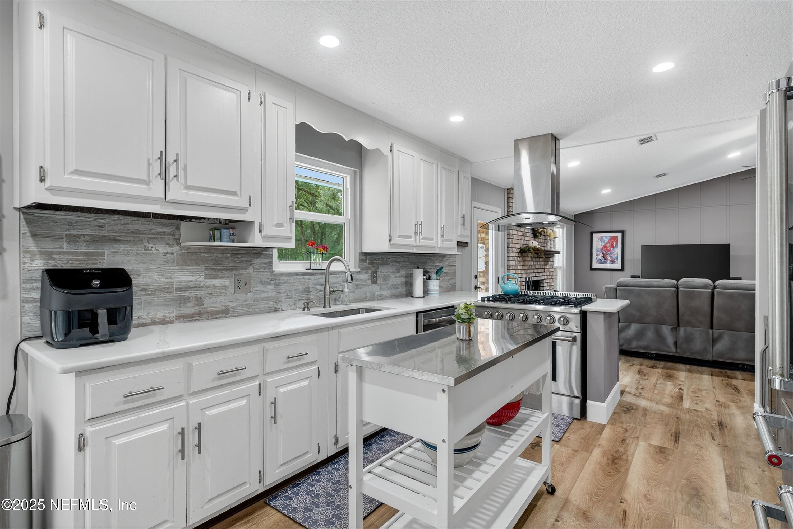 6049 Taylor Road Jacksonville, FL 32234 - Photo 22 of 60 a kitchen with kitchen island granite countertop a sink counter top space appliances and cabinets