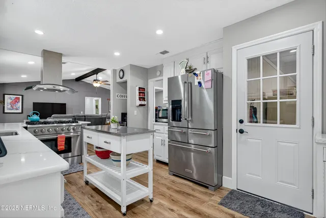 a view of a workspace with bookshelf and a window