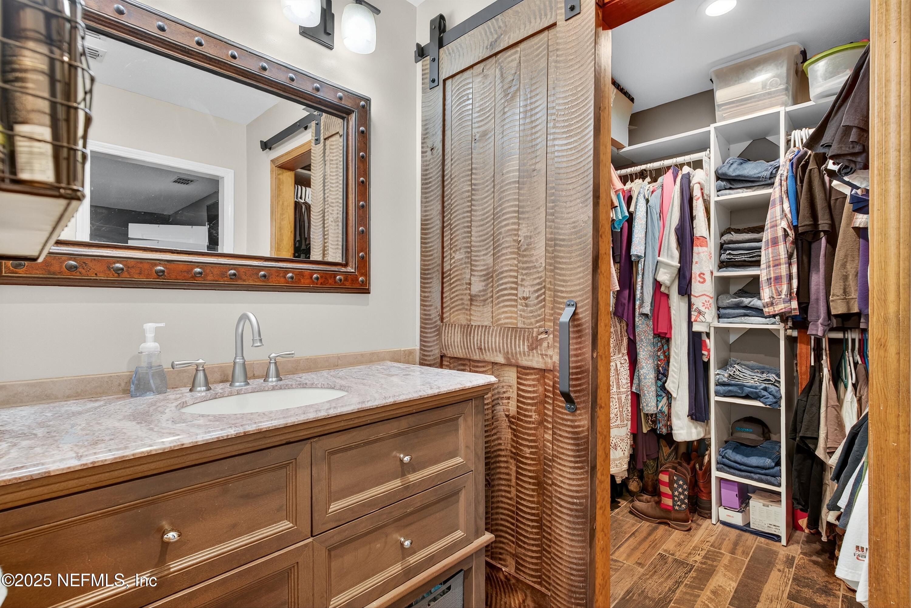 6049 Taylor Road Jacksonville, FL 32234 - Photo 33 of 60 a bathroom with a granite countertop sink a mirror and shower