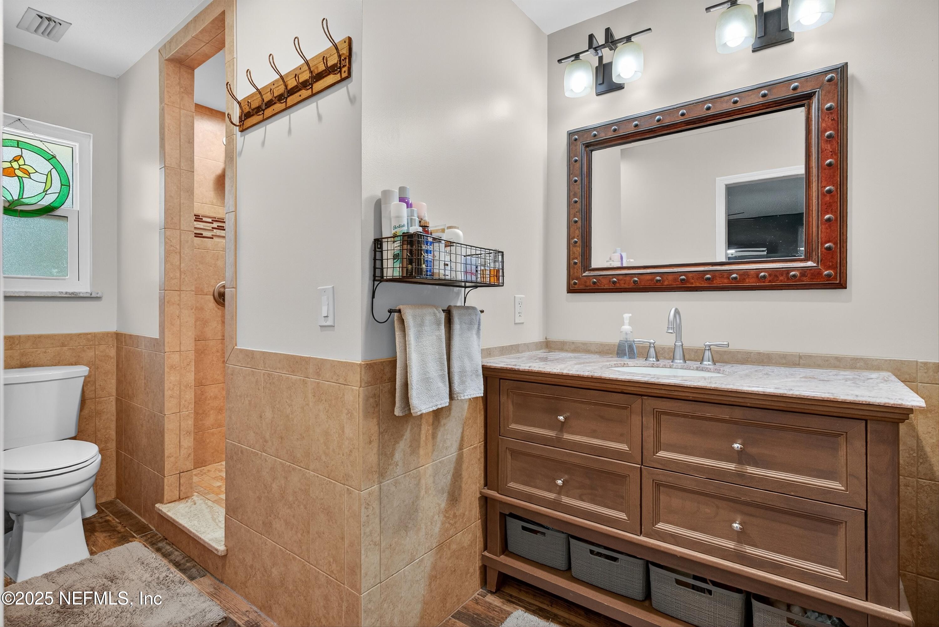 6049 Taylor Road Jacksonville, FL 32234 - Photo 34 of 60 a bathroom with a toilet sink and mirror