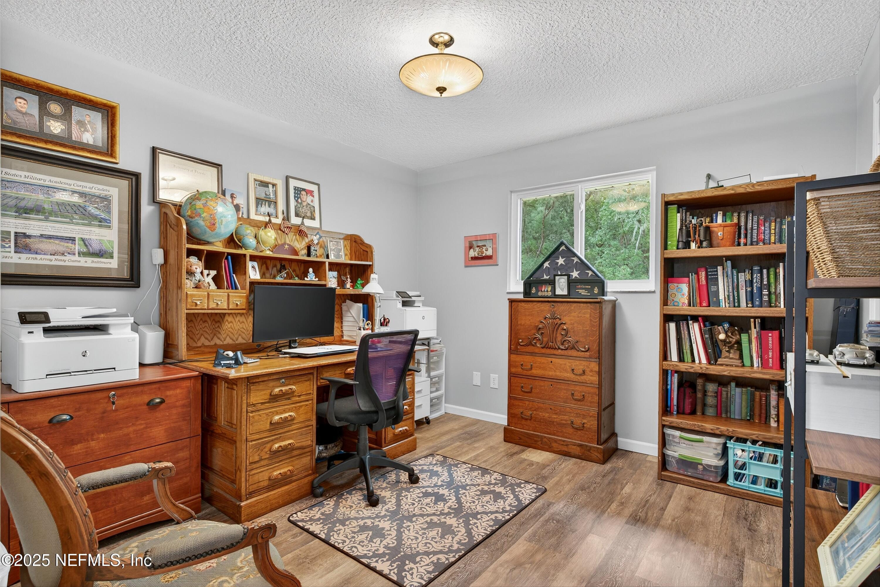 6049 Taylor Road Jacksonville, FL 32234 - Photo 40 of 60 a view of a workspace with furniture and a bookshelf