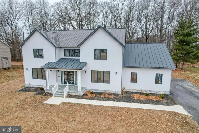 a view of a white house with a yard and large tree