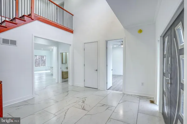 an empty room with wooden floor ceiling fan and windows