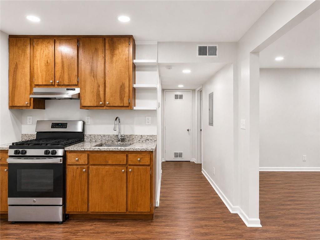 3203 East Point Street, Unit 4 Atlanta, GA 30344 - Photo 8 of 18 a kitchen with granite countertop wooden floors and stainless steel appliances