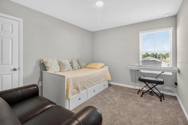 a bedroom with a bed couch and mirror