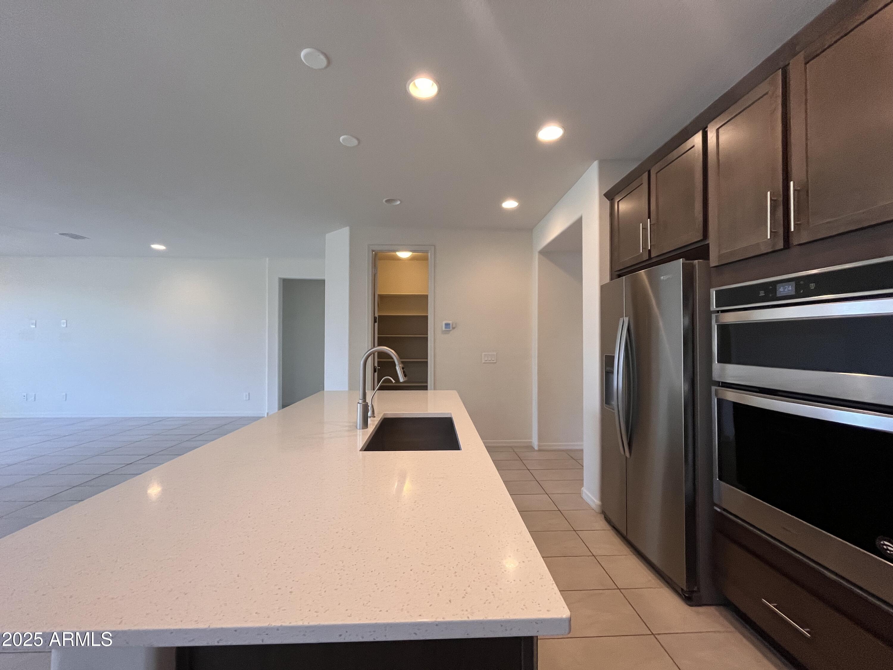 22857 East Marsh Road Queen Creek, AZ 85142 - Photo 17 of 38 a kitchen with stainless steel appliances a refrigerator and a stove top oven