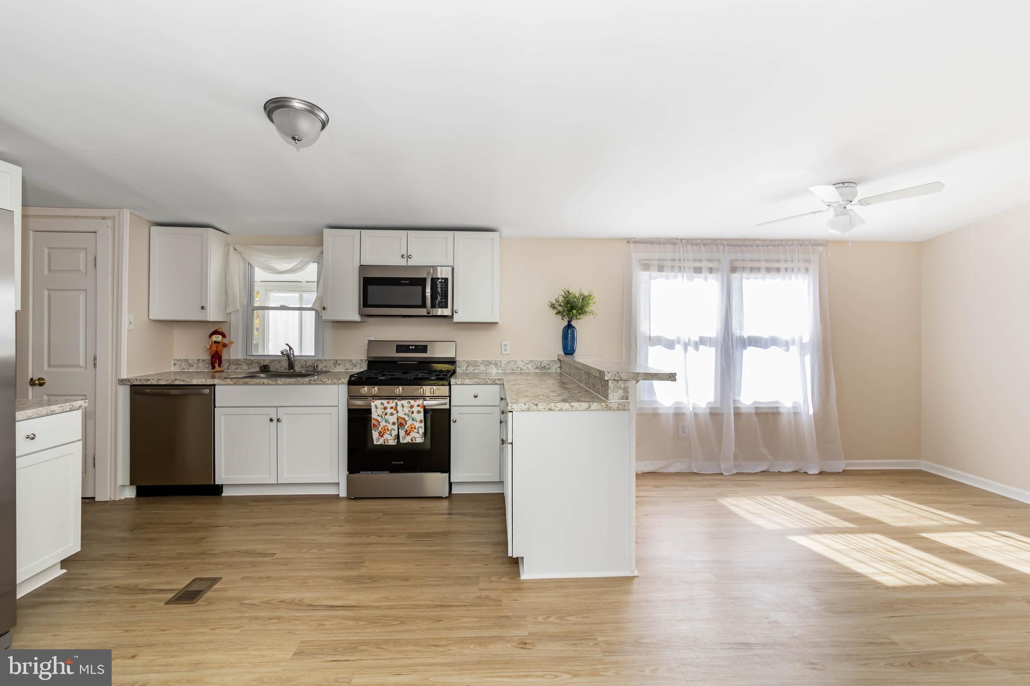 24 Welch Drive Dover, DE 19901 - Photo 6 of 39 a kitchen with granite countertop a stove top oven a sink dishwasher a refrigerator and white cabinets with wooden floor